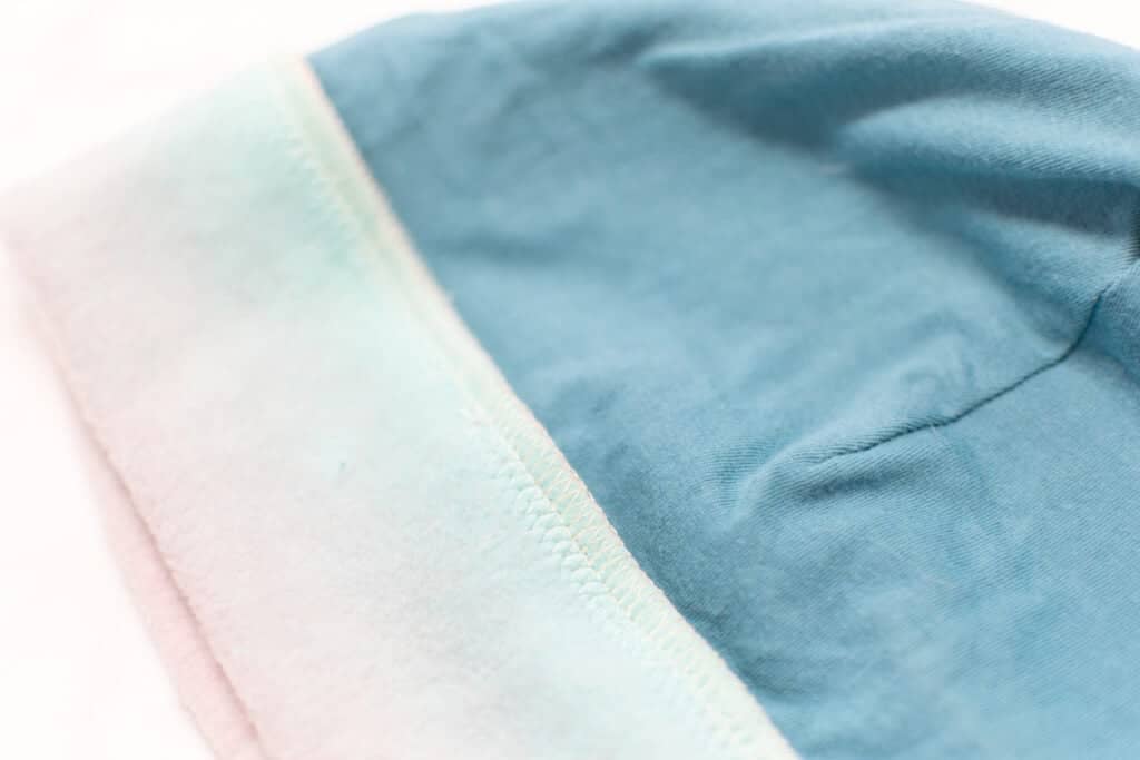 a close up of a blue hat with a seam finished with serging