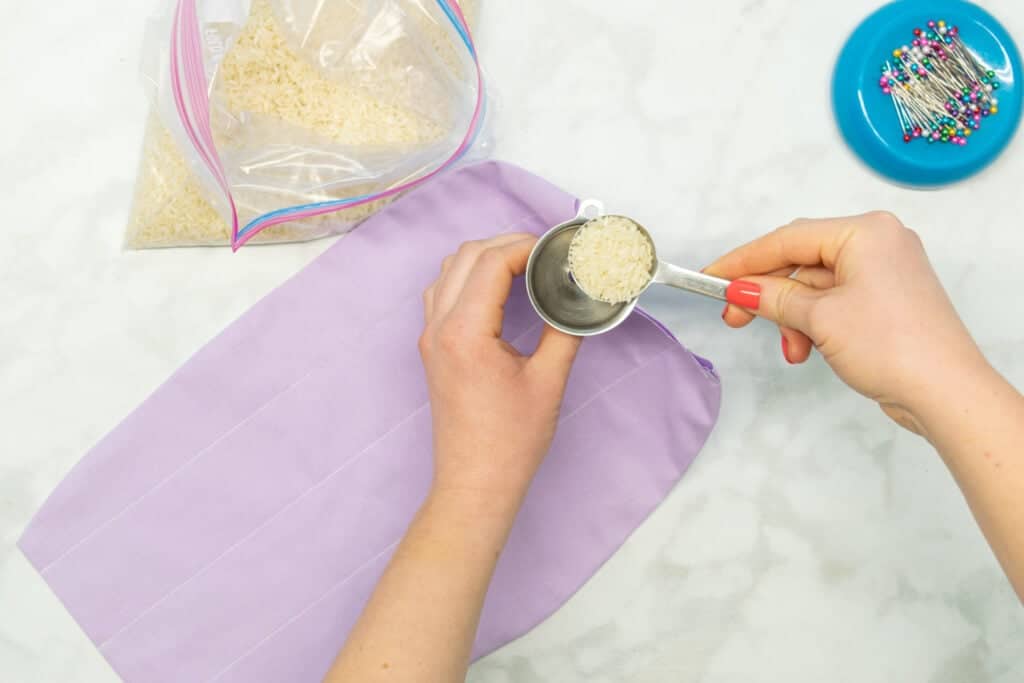 adding rice to a diy heating pad with a metal funnel