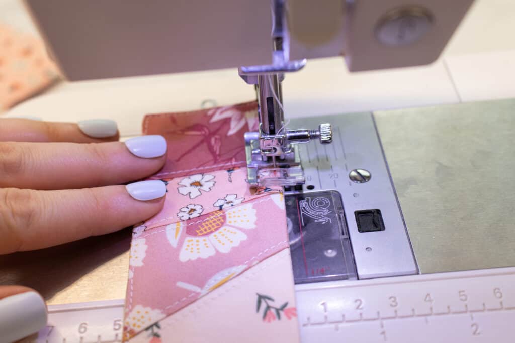 a closeup of a sewing machine showing topstitching the edges of the bookmark