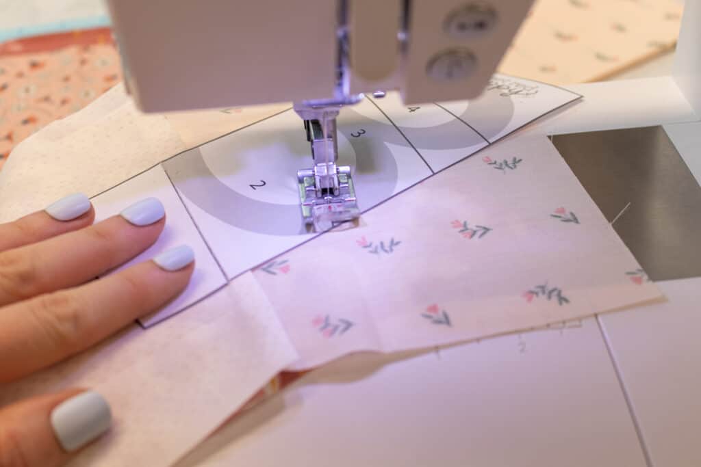 a closeup of a sewing machine sewing the second FPP seam