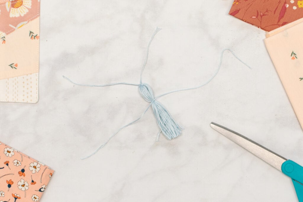 the embroidery floss is tied around the tassel
