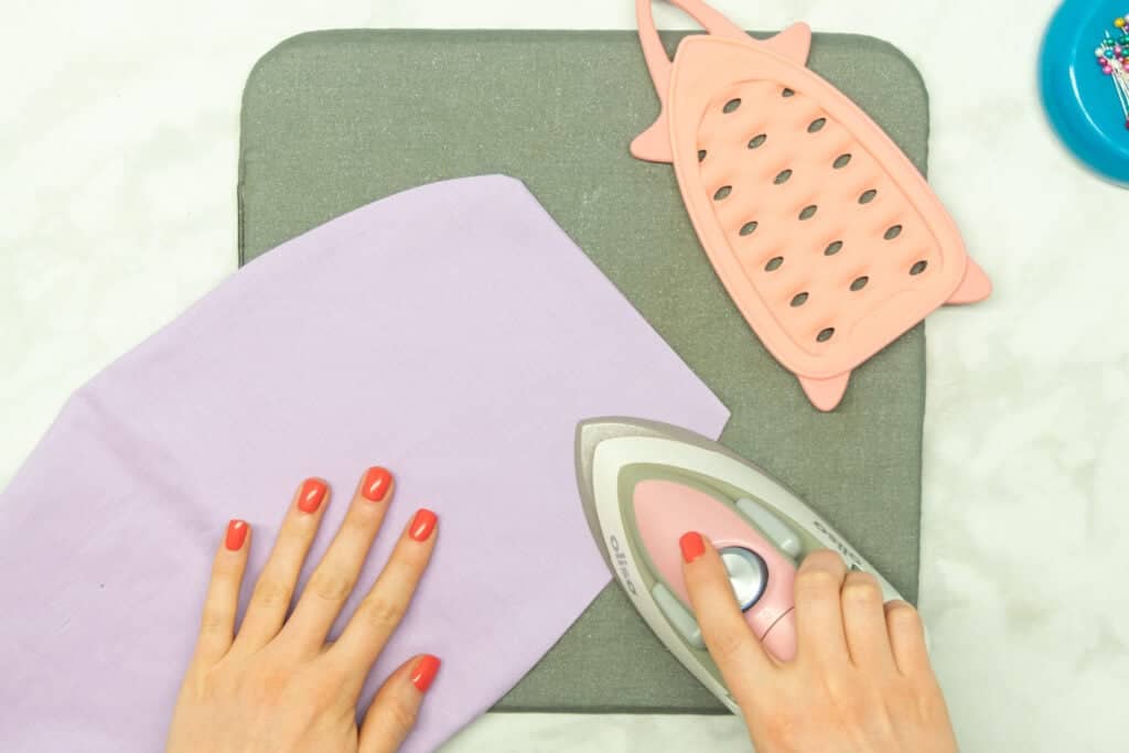 pressing the purple heating pad with a pink iron